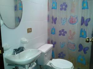 a bathroom with a sink and a toilet and a mirror at Hotel San Andres in Xalapa