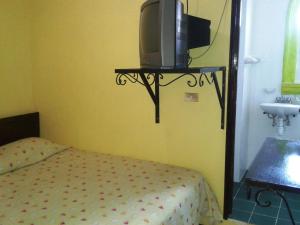a bedroom with a bed and a tv on a shelf at Hotel San Andres in Xalapa