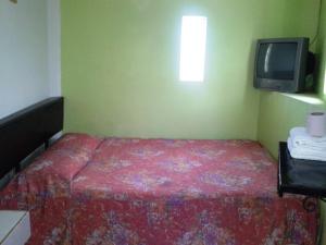 a small bedroom with a bed and a tv at Hotel San Andres in Xalapa