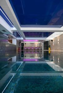 a swimming pool in a building with a blue ceiling at Harry-apartments, Apart Hotel&spa Zoned Kopaonik - Special offer for Genius status for bookings during Early Booker Deal, additionally included parking, swimming pool and children under 13 stay free in Kopaonik