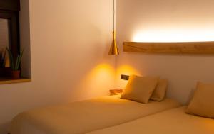 een slaapkamer met een bed met een lamp aan de muur bij Domus Oncinae in Oncina de la Valdoncina