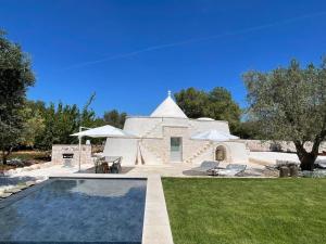 a villa with a swimming pool and a house at OSTUNI MIRROR trullo and mirror house in Carovigno