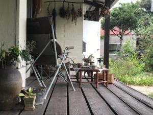 a chair and a table on a porch at Travelers House おーさんてぃん青空舎 in Taketomi