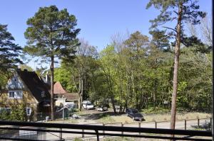 a house with cars parked in a yard with trees at Prima in Krynica Morska