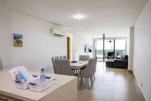 Luxury Apartment PH Bahia Resort, Playa Serena في نويفا جورجونا: مطبخ وغرفة معيشة مع طاولة وكراسي