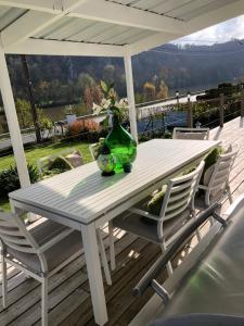 uma mesa branca com um vaso verde e duas cadeiras em Villa Waulsort em Waulsort