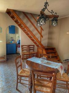 uma sala de jantar com uma mesa de madeira e cadeiras em AL CORNIOLO em Zerba