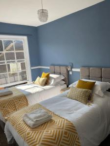 2 camas en una habitación con paredes azules en The White Hart, en Whitchurch