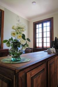 eine Vase mit weißen Blumen auf einem Holztisch in der Unterkunft RIO TIGRE HOTEL in Tigre