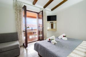 a bedroom with a bed with a view of the ocean at Galapagus privat beach & boat dock in Metajna