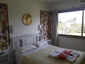 1 dormitorio con 1 cama con 2 toallas en Chajari Suites en Chajarí