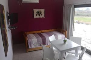 1 dormitorio con 1 cama, mesa y sillas en Chajari Suites en Chajarí