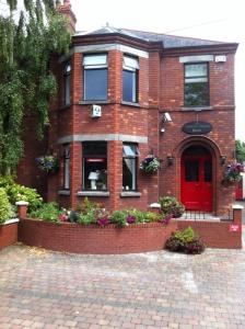 ein rotes Backsteinhaus mit einer roten Tür in der Unterkunft Ashling House Serviced Accommodation in Dublin