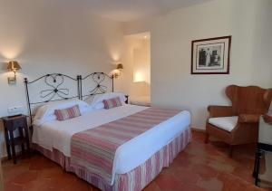 a bedroom with a large bed and a chair at miKasa Agua Amarga & SPA in Agua Amarga