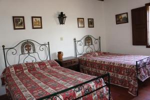 1 dormitorio con 2 camas y mantas rojas en Quinta das Arribas, en Abrantes