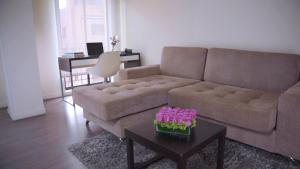 a living room with a couch and a table with flowers at Central Apartamentos Bogotá in Bogotá +70 photos