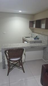 a kitchen with a counter with a chair and a sink at Flat 427, Imperial Flat Tambau NOBILE in João Pessoa
