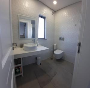 a white bathroom with a sink and a toilet at Lovely Home, WIFI, Jardim in Armação de Pêra +8 photos
