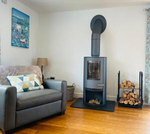 a living room with a couch and a wood stove at Sunny Corner, Padstow. Spacious 3 bedrooms, 2.5 bathrooms, parking, garden. in Padstow