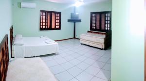 um quarto branco com uma cama e uma cómoda em Paraíso do sul - Carmery em Pontal do Paraná