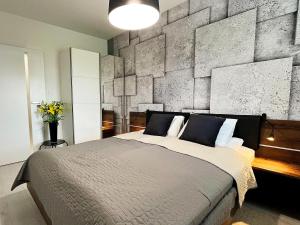 sypialnia z dużym łóżkiem i kamienną ścianą w obiekcie SKi&bike apartments w Szczyrku