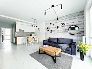 salon z niebieską kanapą i stołem w obiekcie SKi&bike apartments w Szczyrku