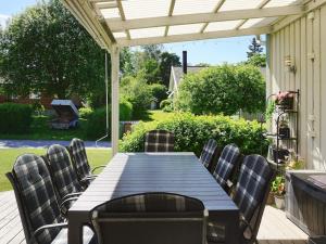 a wooden table and chairs on a patio at 9 person holiday home in SOLLENTUNA in Sollentuna