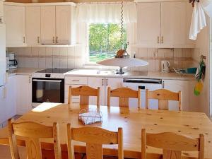 een keuken met een houten tafel en houten stoelen bij 4 person holiday home in Byxelkrok in Byxelkrok