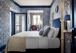 a bedroom with a large bed with blue wallpaper at The Randolph Hotel Oxford, a Graduate by Hilton Hotel in Oxford