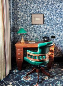 an office with a desk and a green chair at The Randolph Hotel Oxford, a Graduate by Hilton Hotel in Oxford