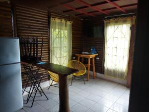 cocina con mesa, sillas y nevera en Cabaña para vacacionar río Sarapiqui, en Sarapiquí