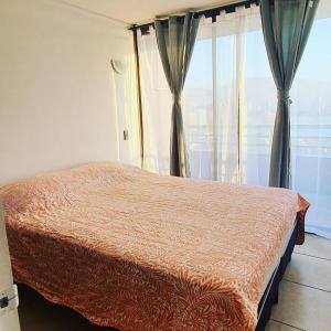 a bedroom with a bed and a large window at Departamento NEO IQUIQUE VISTA AL MAR 3 in Iquique
