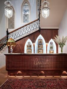 a large room with a staircase and a table with a sign at The Randolph Hotel, by Graduate Hotels in Oxford