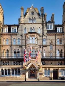 an old building with two british flags in front at The Randolph Hotel, by Graduate Hotels in Oxford