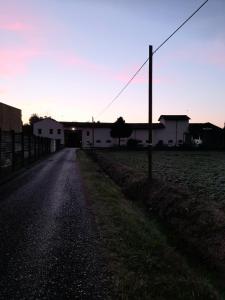 un camino vacío en un campo con una casa en Appartamento in Cascina Cortazza en Cremona