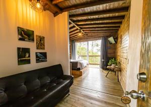 a living room with a black couch and a bedroom at Cerro Verde Mirador in Medellín