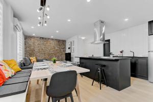 a kitchen and living room with a dining table and a counter at Les Appartements du 300 in Quebec City +32 photos