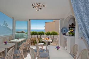 un ristorante con tavoli e sedie e una grande finestra di Villa La Tartana a Positano