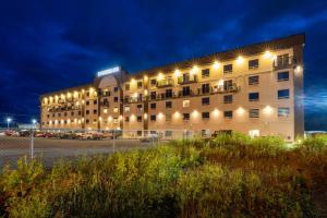 a large building with lights on the side of it at Quality Inn Sunshine Suites in Terrace