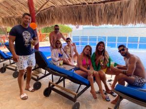 a group of people sitting on the beach at Hotel Isla Real in Tierra Bomba