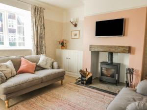 a living room with a couch and a fireplace at Yew Court Cottage in Scarborough