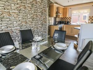 a kitchen with a table and chairs and a stone wall at 16 Badgers Retreat in Richmond