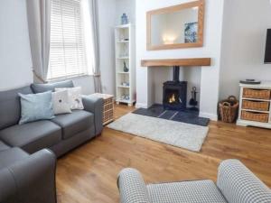 a living room with a couch and a fireplace at Silversands Cottage in Amble