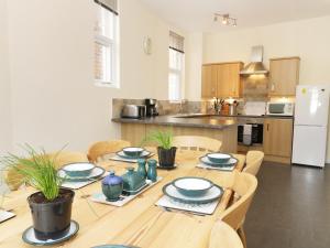 a kitchen with a wooden table with plates on it at The Sea Glass Loft in Hornsea