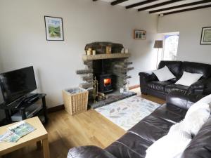 a living room with a couch and a fireplace at Hope Cottage in Leyburn