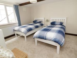 a bedroom with two beds and a window at Hope Cottage in Leyburn