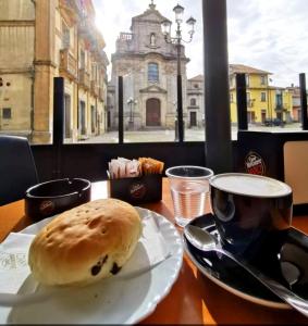 - une assiette avec une viennoiserie sur une table accompagnée d'une tasse de café dans l'établissement Il Vico, à Serra San Bruno