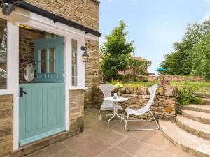 a door leading to a patio with a table and chairs at The Dale Cottage in Allendale Town