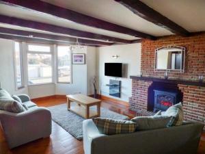 a living room with two couches and a fireplace at Smugglers' Cottage in Marske-by-the-Sea
