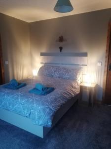 a bedroom with a bed with two blue towels on it at Self catering upstairs apartment at Tradcottage in Sligo